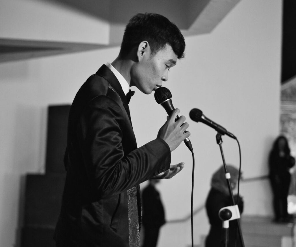 Homem asiático fazendo uma classificação vocal no microfone